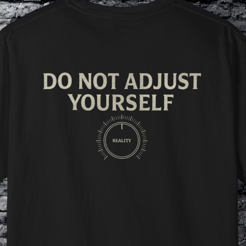 Black t-shirt with 'DO NOT ADJUST YOURSELF' text and a dial graphic on a brick wall background