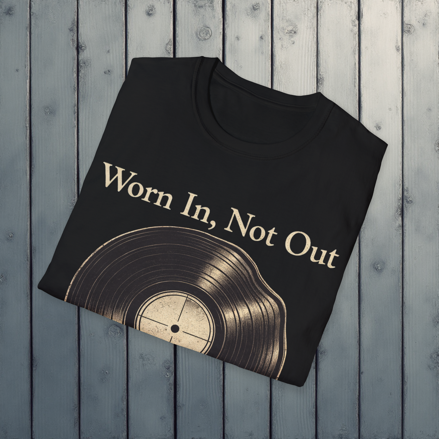 Black t-shirt with vinyl record design and 'Worn In, Not Out' text on a wooden surface