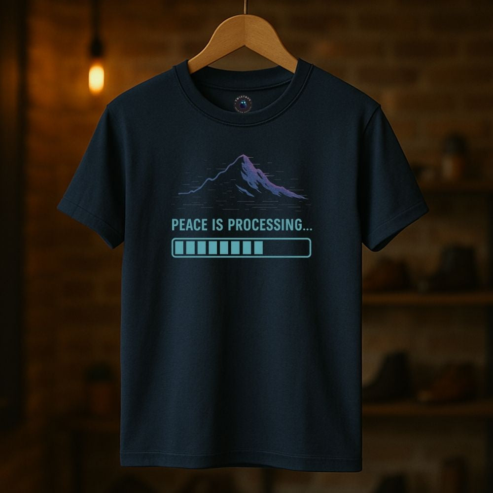 Navy “Peace Is Processing” T-shirt hanging indoors with neon-style mountain and progress bar graphic, cozy ambient light.