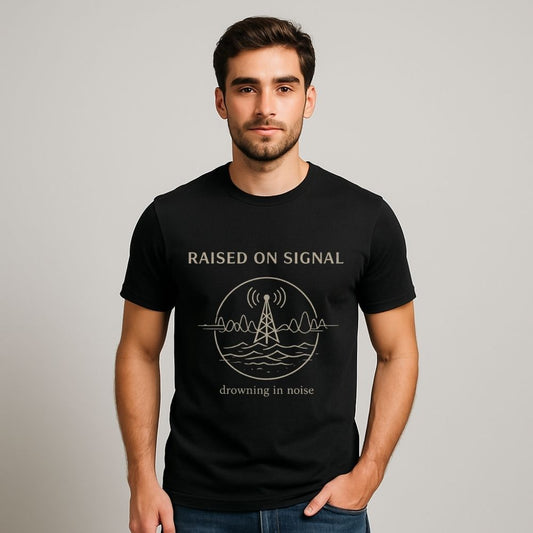 Man wearing a black t-shirt with 'Raised on Signal' design on a plain background