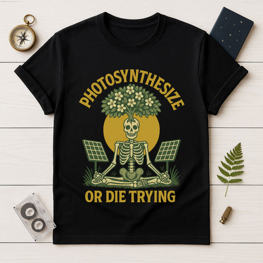 Black t-shirt with skeleton and plant design on a wooden surface with decorative items.