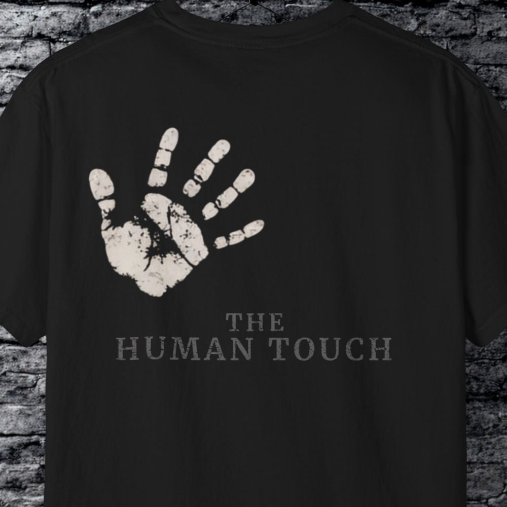 Black t-shirt with a handprint and 'The Human Touch' text on a brick wall background