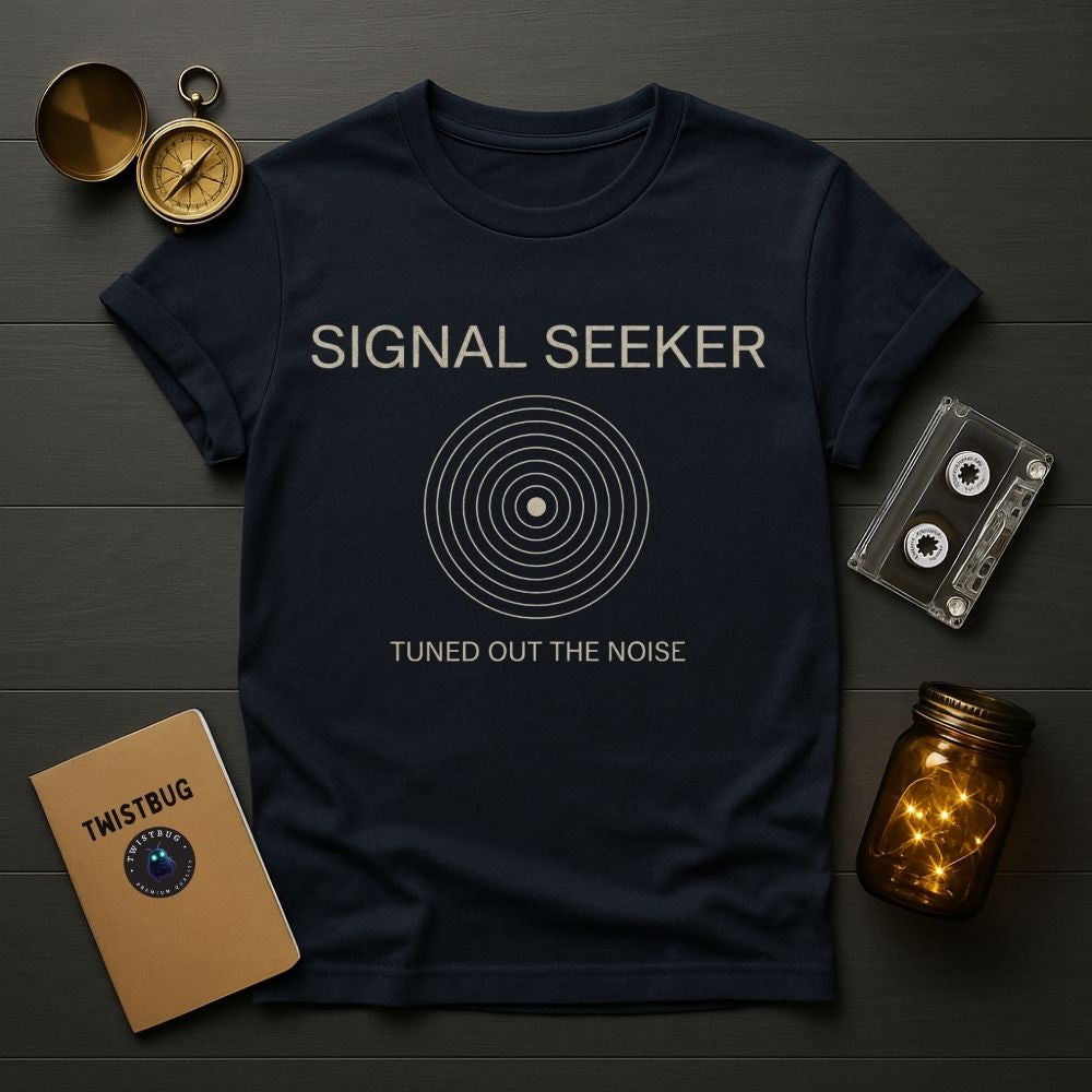 Navy blue t-shirt with 'Signal Seeker' design on a wooden surface with vintage items.