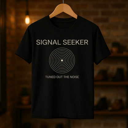 Black t-shirt with 'Signal Seeker' design on a wooden hanger against a dark background