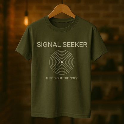 Green t-shirt with 'Signal Seeker' text on a hanger against a blurred background