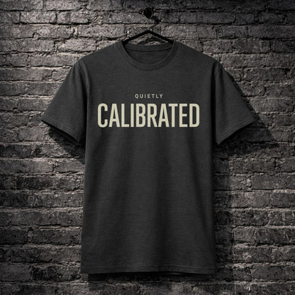 Black t-shirt with 'CALIBRATED' text on a brick wall background