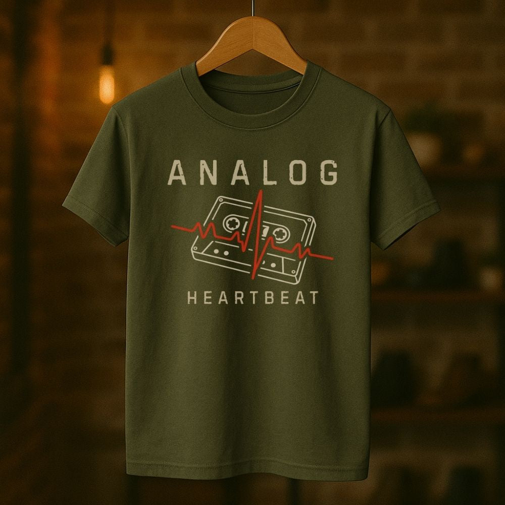 Green t-shirt with 'Analog Heartbeat' design on a wooden hanger against a blurred background
