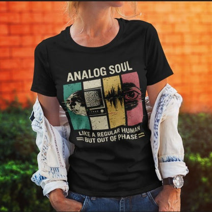 Person wearing a black t-shirt with 'Analog Soul' design against an orange wall.