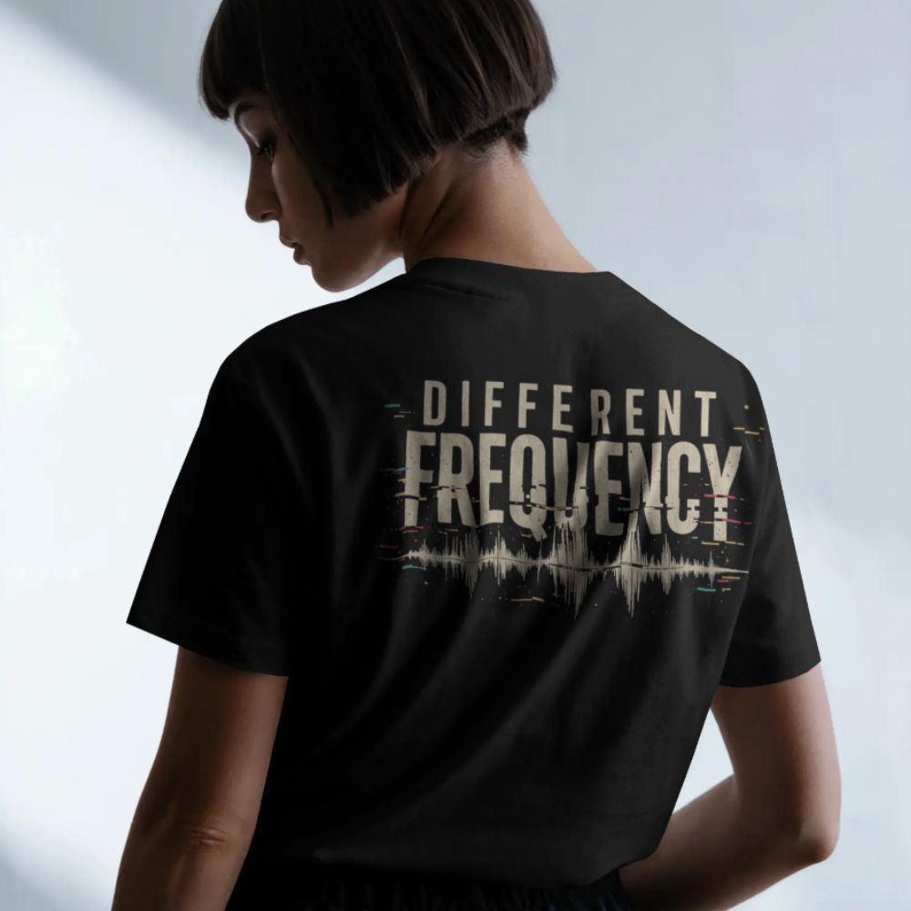Person wearing a black t-shirt with 'DIFFERENT FREQUENCY' text on the back, standing against a light background.