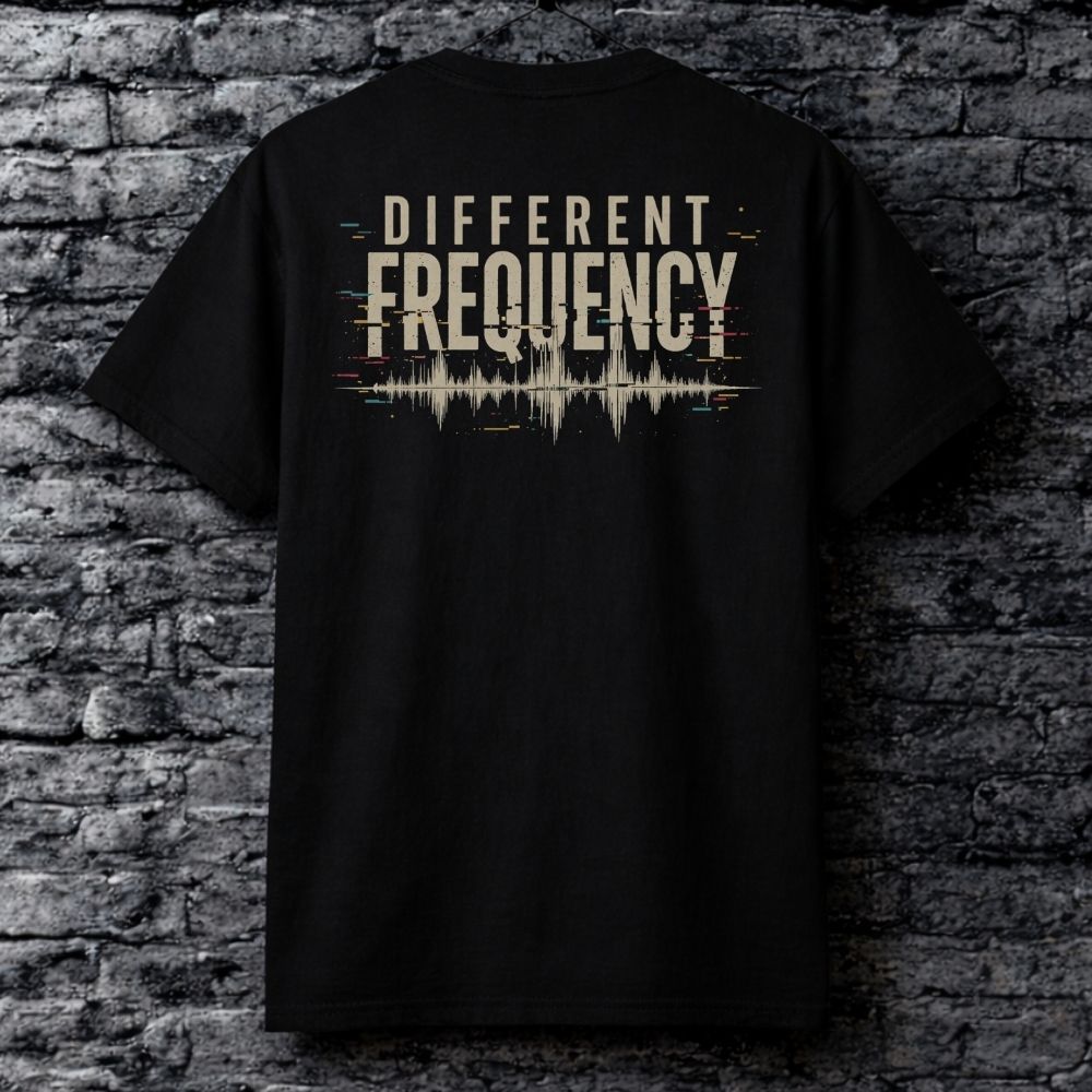 Black t-shirt with 'Different Frequency' design on a brick wall background