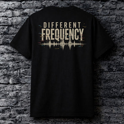 Black t-shirt with 'Different Frequency' design on a brick wall background