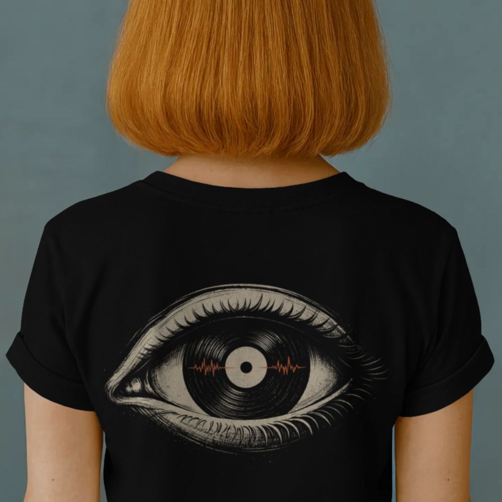 Person wearing a black t-shirt with an eye design on the back against a gray background