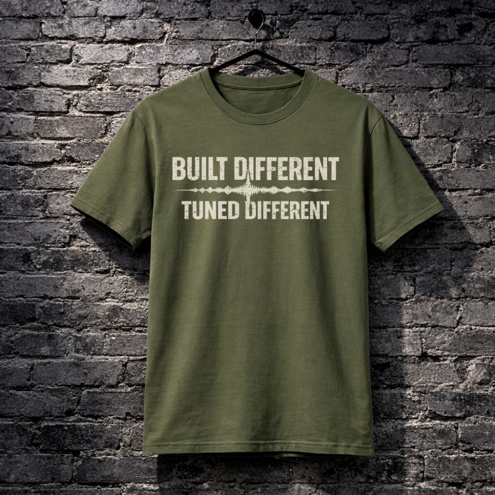 Green t-shirt with text 'Built Different Tuned Different' on a brick wall background