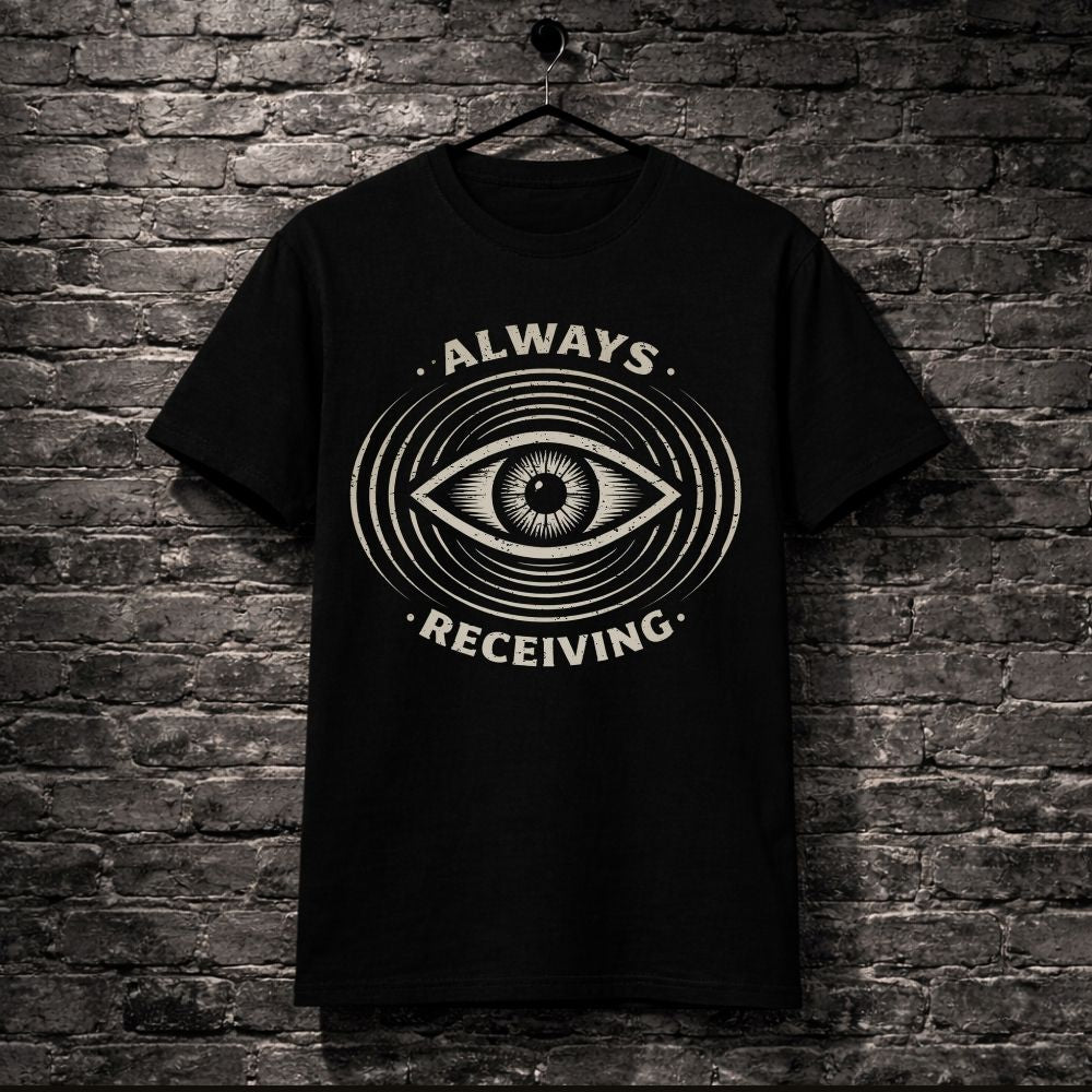 Black t-shirt with eye design and 'Always Receiving' text on a brick wall background