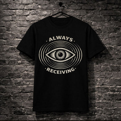 Black t-shirt with eye design and 'Always Receiving' text on a brick wall background