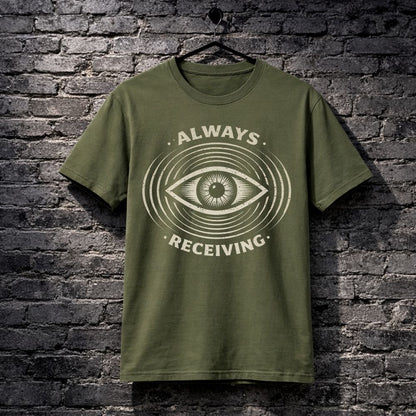 Green t-shirt with eye design and text 'Always Receiving' on a brick wall background