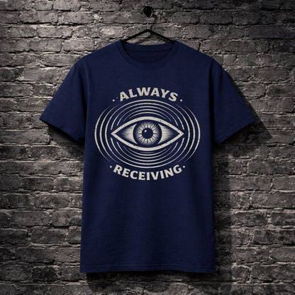 Navy blue t-shirt with eye design and text 'Always Receiving' on a brick wall background