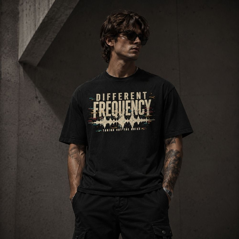 Man wearing a black t-shirt with 'Different Frequency' design against a dark background