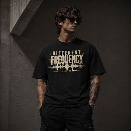Man wearing a black t-shirt with 'Different Frequency' design against a dark background