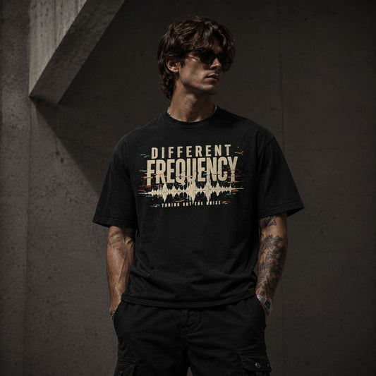 Man wearing a black t-shirt with 'Different Frequency' design against a dark background