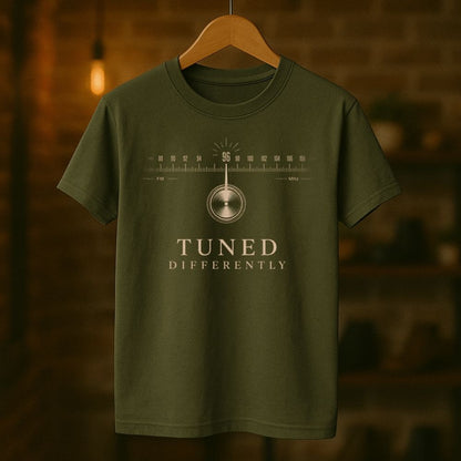 Green t-shirt with 'Tuned Differently' design on a wooden hanger against a blurred background
