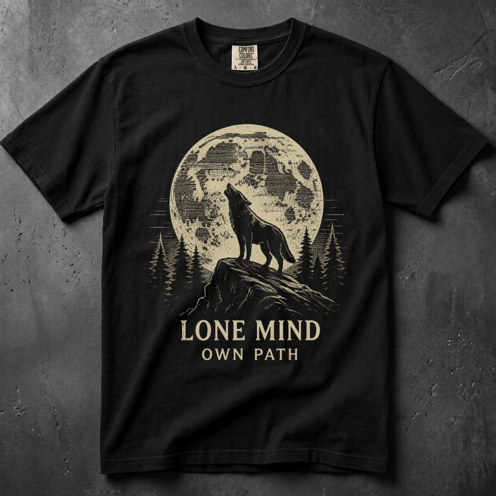 A black short-sleeve graphic t-shirt laid flat on a dark textured background. The shirt features a large cream-colored graphic of a wolf howling at a moon over pine trees, with the text 'LONE MIND OWN PATH' printed below.