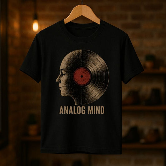 Black t-shirt with vinyl record and face design on a hanger against a brick wall background