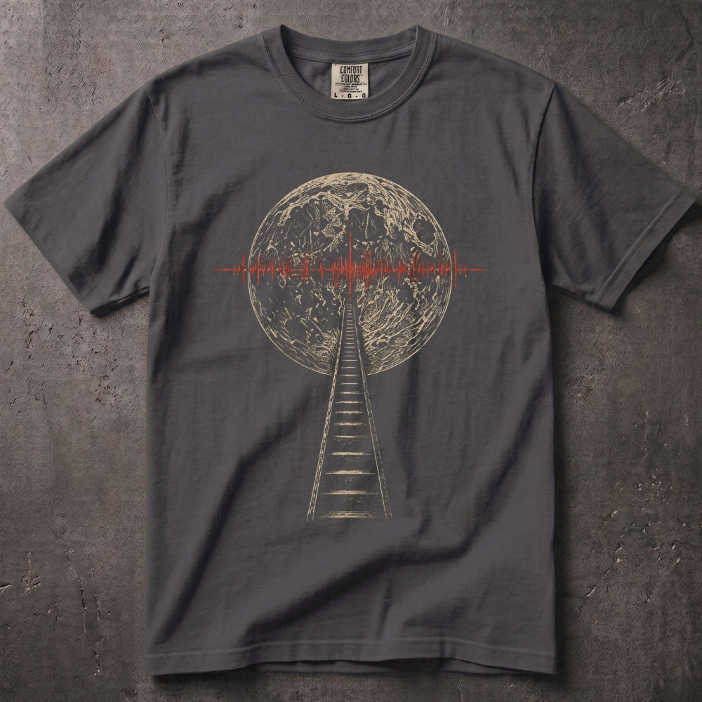 A dark gray crewneck t-shirt featuring a graphic print of a staircase leading up to a full moon, with a red soundwave line crossing the moon's horizon. The shirt is laid flat on a textured gray concrete surface.