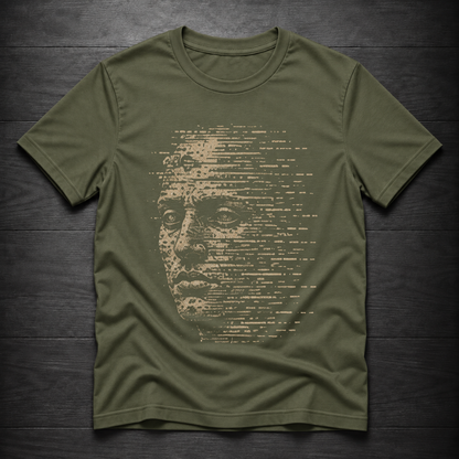 An olive green crewneck t-shirt featuring a distressed graphic print of a human face composed of horizontal text, laid flat on a dark wood plank background.