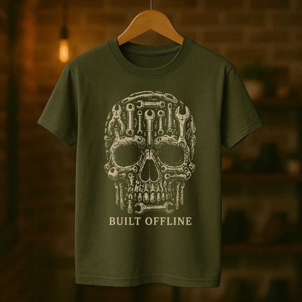 Green t-shirt with a mechanical skull design and 'BUILT OFFLINE' text on a wooden hanger against a blurred background.