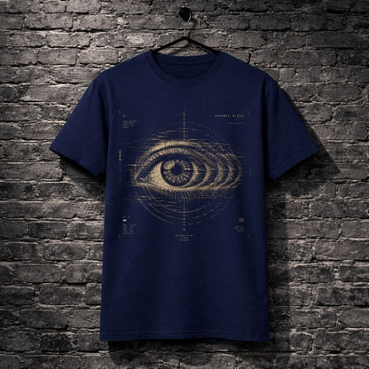 A navy blue short-sleeve t-shirt hanging on a black hanger against a dark gray brick wall. The shirt features a detailed graphic print of a human eye in beige and gold, surrounded by circular technical blueprint markings and the text 'CHARLES BLISS'.