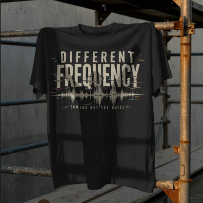 Black t-shirt with 'Different Frequency' design on a wooden surface.