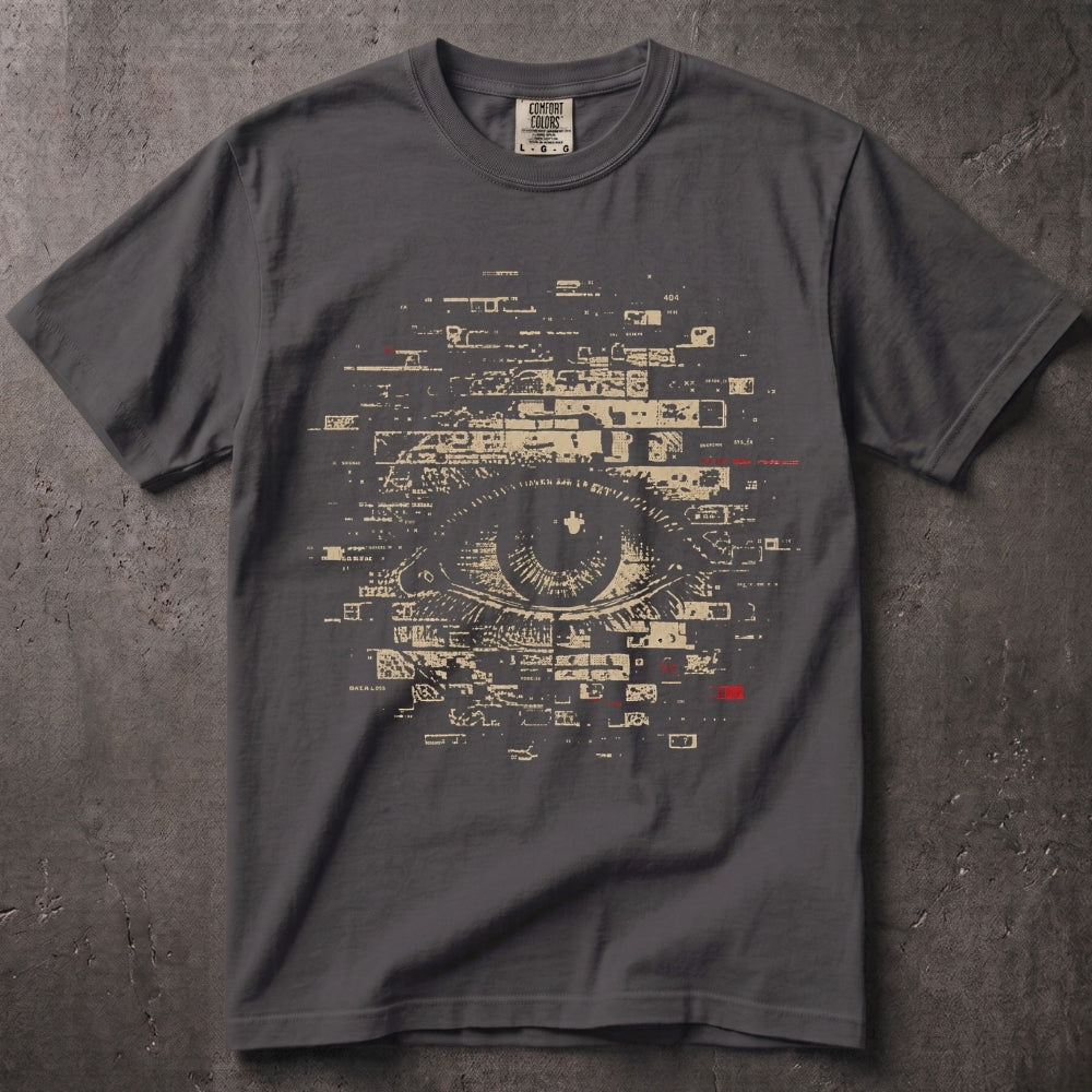 A dark gray crewneck t-shirt featuring a large graphic print of a stylized eye composed of digital interface elements and text, with small red accents, laid flat on a textured gray background.
