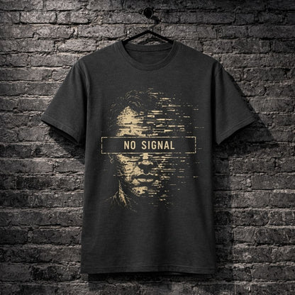 A dark charcoal gray t-shirt hanging on a black hanger against a dark gray brick wall. The shirt features a distressed graphic of a face with pixelated details and a central horizontal bar with the text 'NO SIGNAL' in gold.