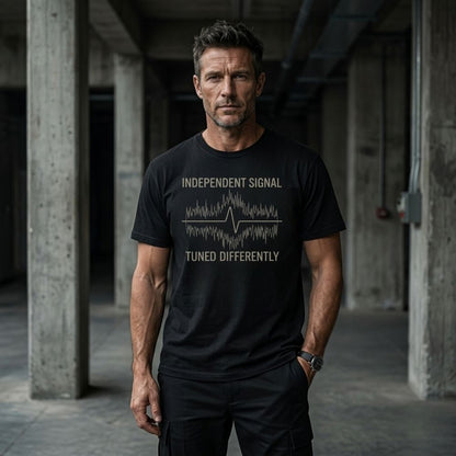 Man wearing a black t-shirt with text in an industrial setting