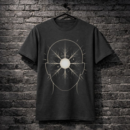 A dark charcoal gray t-shirt hanging on a black hanger against a dark gray brick wall. The shirt features a white graphic print of a stylized human head silhouette with a circular center and branching line details.