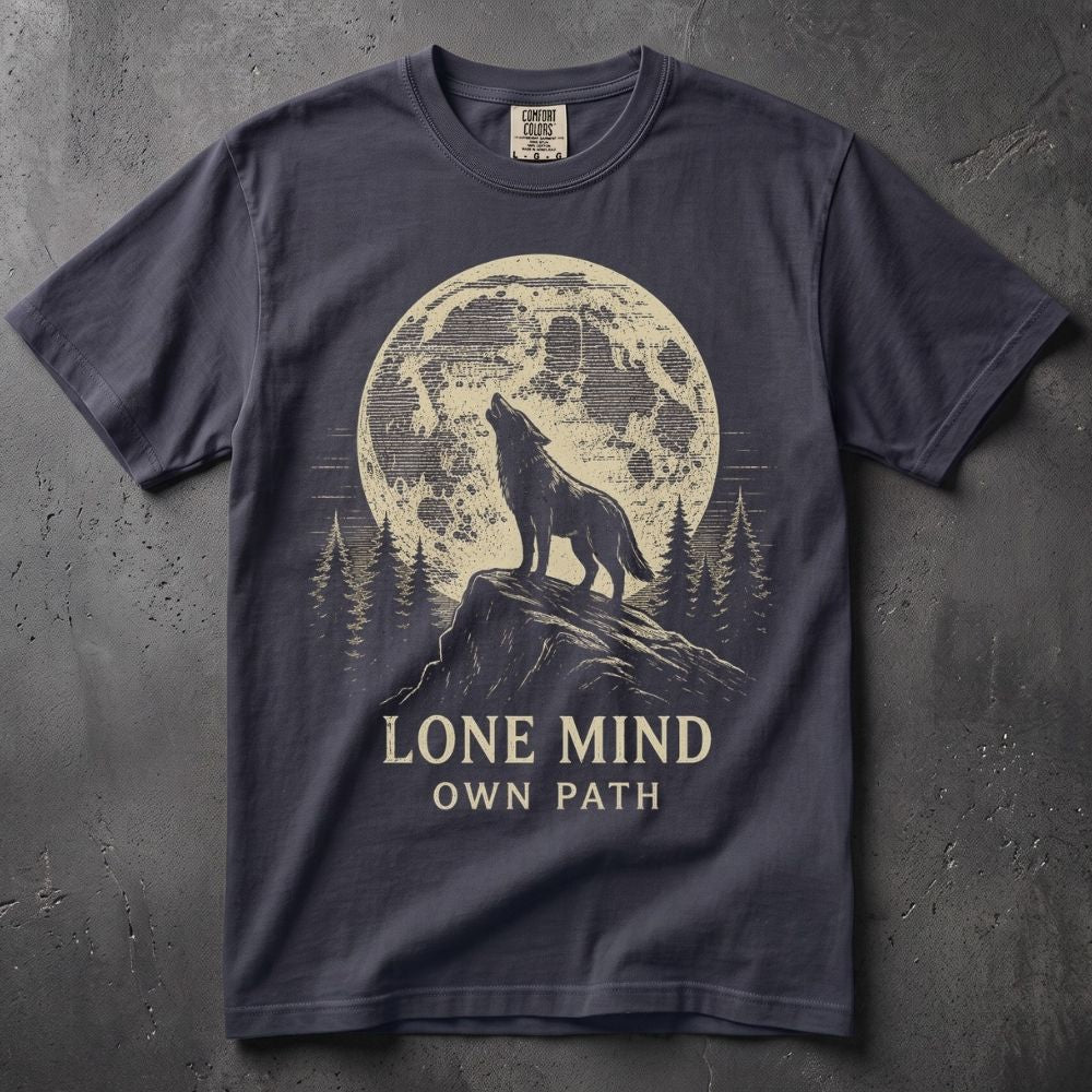 A navy blue short-sleeve t-shirt with a graphic print of a wolf howling in front of a moon that reads 'LONE MIND' and a mountain peak that reads 'OWN PATH'. The shirt is laid flat on a textured gray background.
