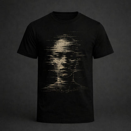 A black short-sleeve crewneck t-shirt featuring a distressed, pixelated graphic of a human face in a light beige or cream color on the front, displayed against a dark gray background.