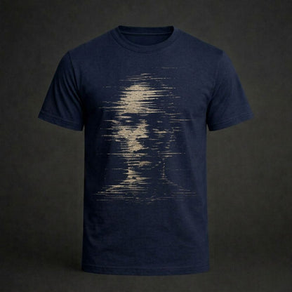 A navy blue short-sleeve crewneck t-shirt featuring a distressed, pixelated graphic of a face on the front, displayed against a dark gray background.