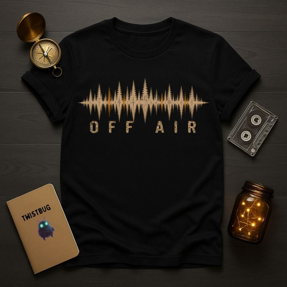 Black t-shirt with 'OFF AIR' design on a wooden surface with decorative items.