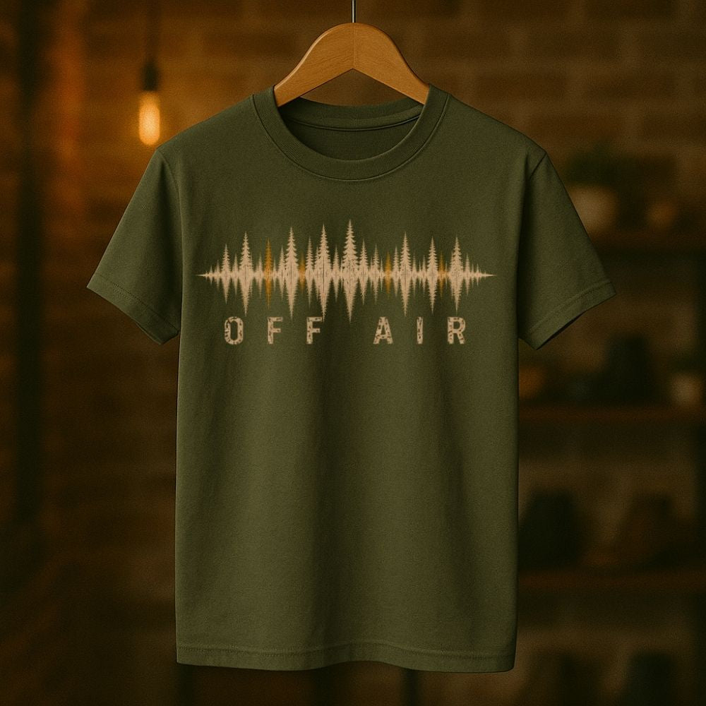 Green t-shirt with 'OFF AIR' graphic design on a wooden hanger against a blurred background