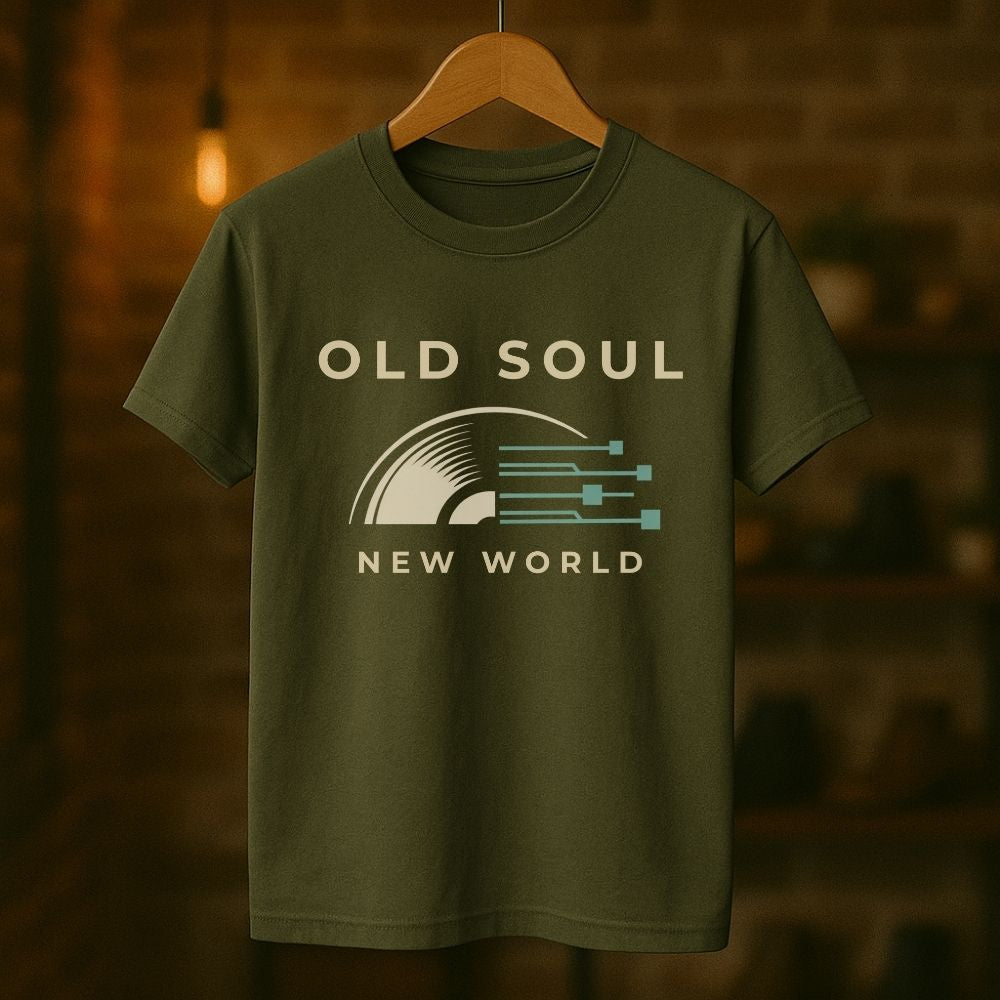 Green t-shirt with 'Old Soul New World' text and graphic on a wooden hanger against a blurred background.