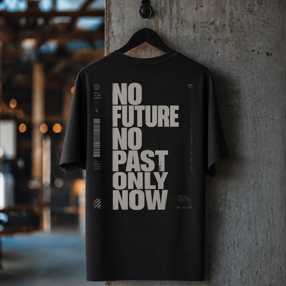 Black t-shirt with 'No Future No Past Only Now' text on a hanger against a concrete wall.