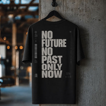 Black t-shirt with 'No Future No Past Only Now' text on a hanger against a concrete wall.