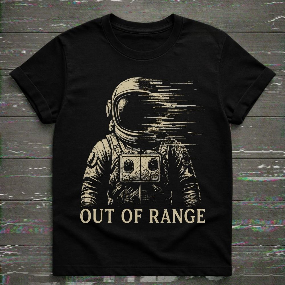 Black t-shirt with an astronaut graphic and 'Out of Range' text on a wooden surface.