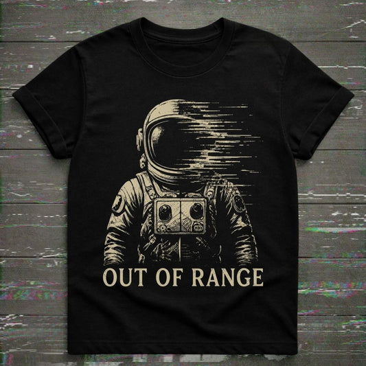 Black t-shirt with an astronaut graphic and 'Out of Range' text on a wooden surface.