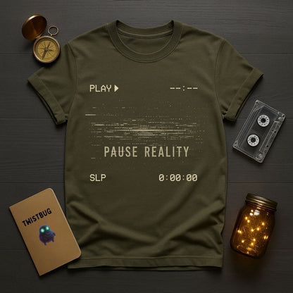 Green t-shirt with 'Play Pause Reality' text on a wooden surface with vintage items.