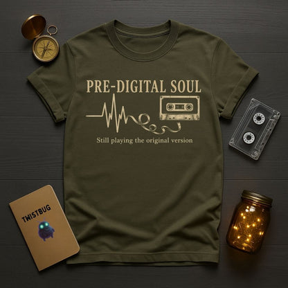 Green t-shirt with 'Pre-Digital Soul' design on a wooden surface with vintage items.