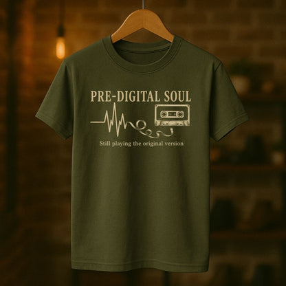 Green t-shirt with 'Pre-Digital Soul' text and cassette tape graphic on a wooden hanger against a blurred background.