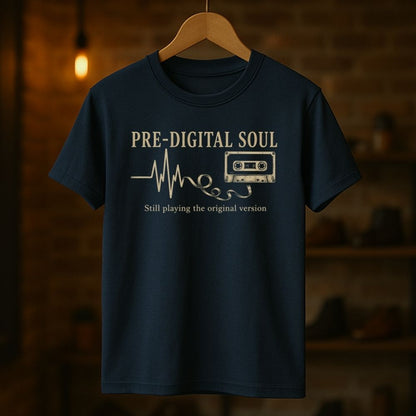 Navy blue t-shirt with 'Pre-Digital Soul' text and cassette tape graphic on a wooden hanger against a dark background.